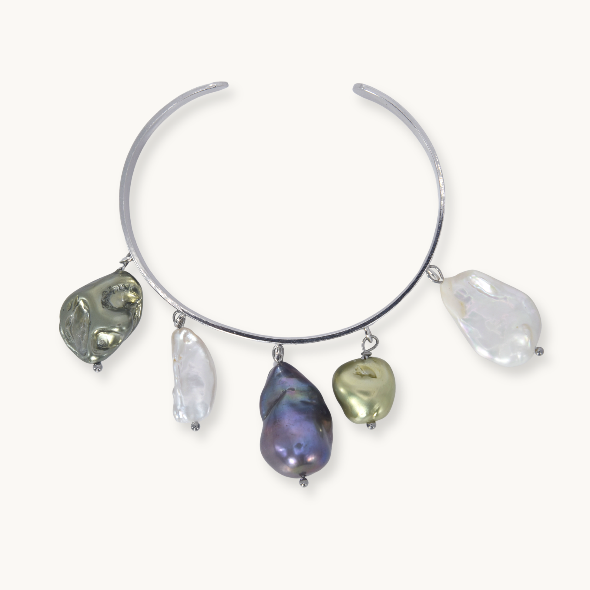 A silver-toned open cuff necklace featuring five irregular baroque pearl charms in various colors including olive green, white, iridescent purple, and metallic gold, displayed on a light cream background.