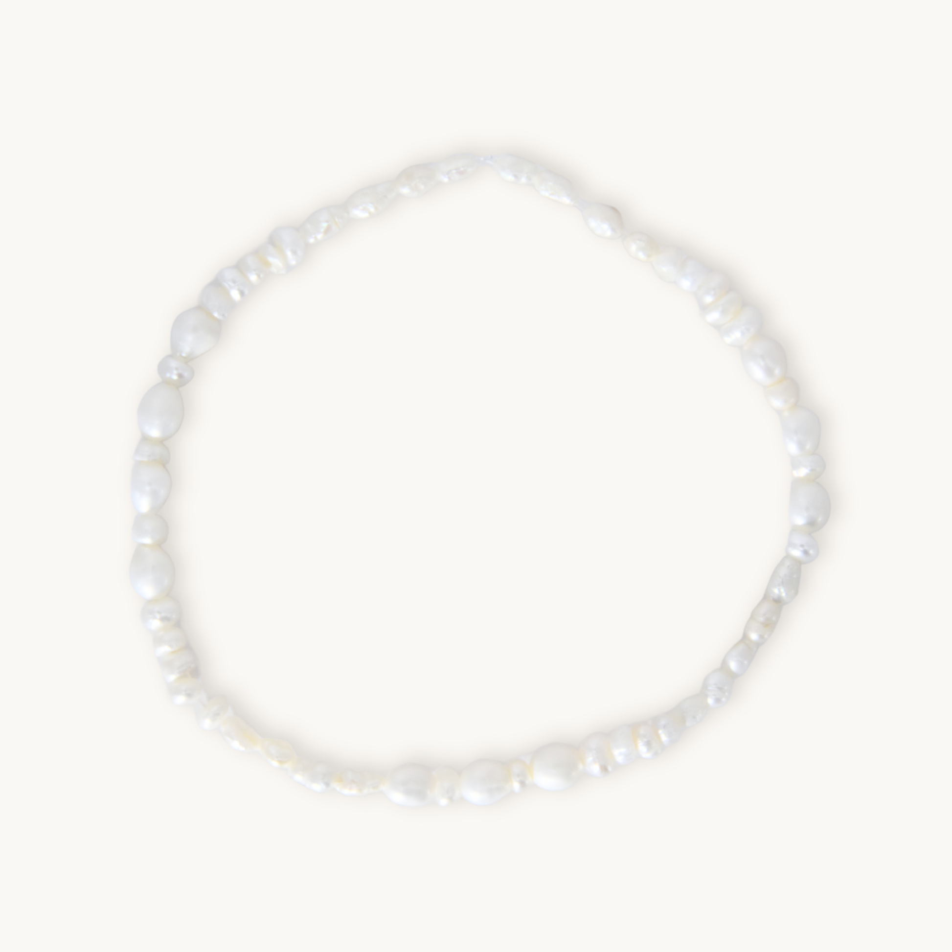 A barely-there pearl bracelet featuring organically shaped white pearls on a comfortable elastic band, designed for effortless, everyday wear. Lightweight and flexible, it slips on with ease, making it perfect under scrubs or as the finishing touch to your most polished look.