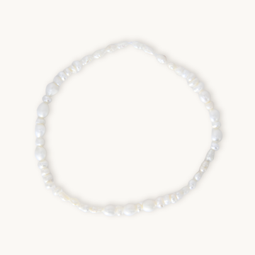 A barely-there pearl bracelet featuring organically shaped white pearls on a comfortable elastic band, designed for effortless, everyday wear. Lightweight and flexible, it slips on with ease, making it perfect under scrubs or as the finishing touch to your most polished look.