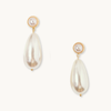 Elegant gold earrings featuring round pearl studs and elongated teardrop-shaped pearls, set against a plain white background, exuding a sophisticated tone.