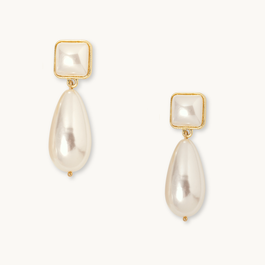 Elegant pearl drop earrings with gold trim, featuring a square pearl stud and teardrop pearl dangle. The design is classic and sophisticated.