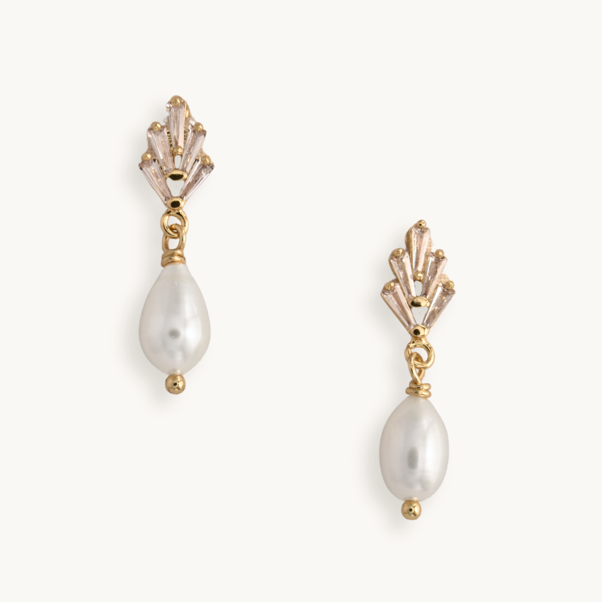 Elegant pearl drop earrings with gold art deco settings, against a plain white background. The design is classic and sophisticated.