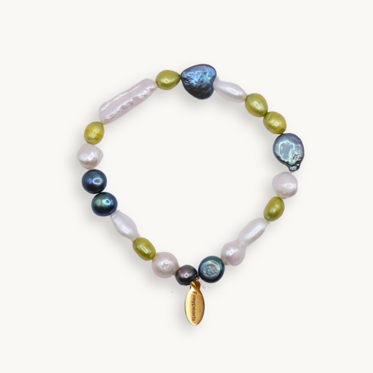 A multicolored pearl bracelet featuring irregularly shaped pearls in shades of blue, green, white, and pink, with a small gold tag reading "Fraypearls."