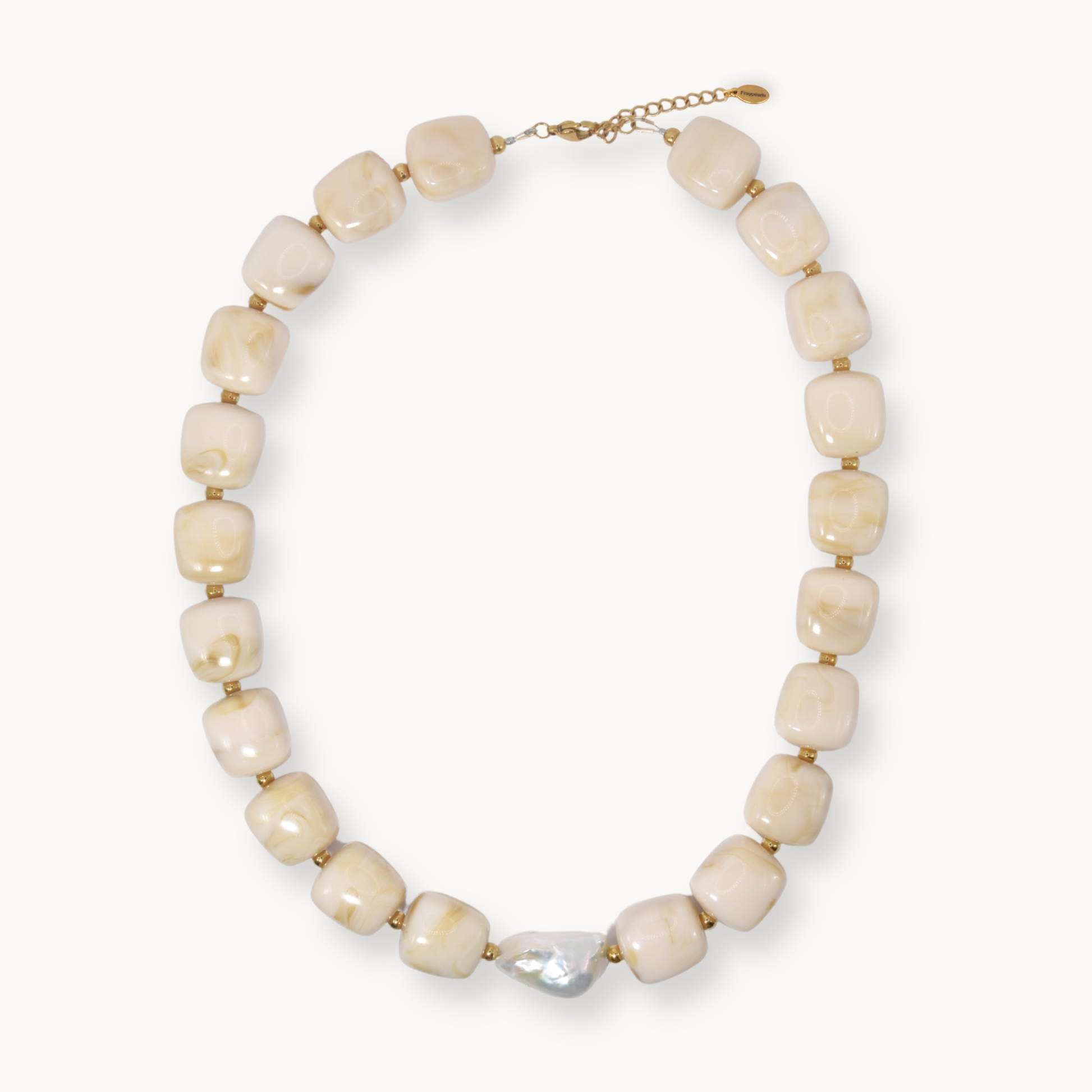 Chunky cream and gold marbled resin bead necklace with a baroque pearl accent, laid flat on a white background.
