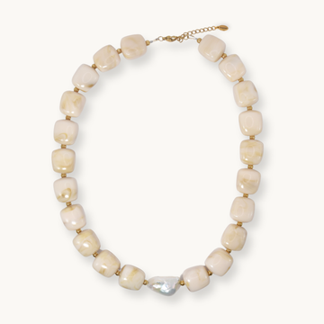 Chunky cream and gold marbled resin bead necklace with a baroque pearl accent, laid flat on a white background.
