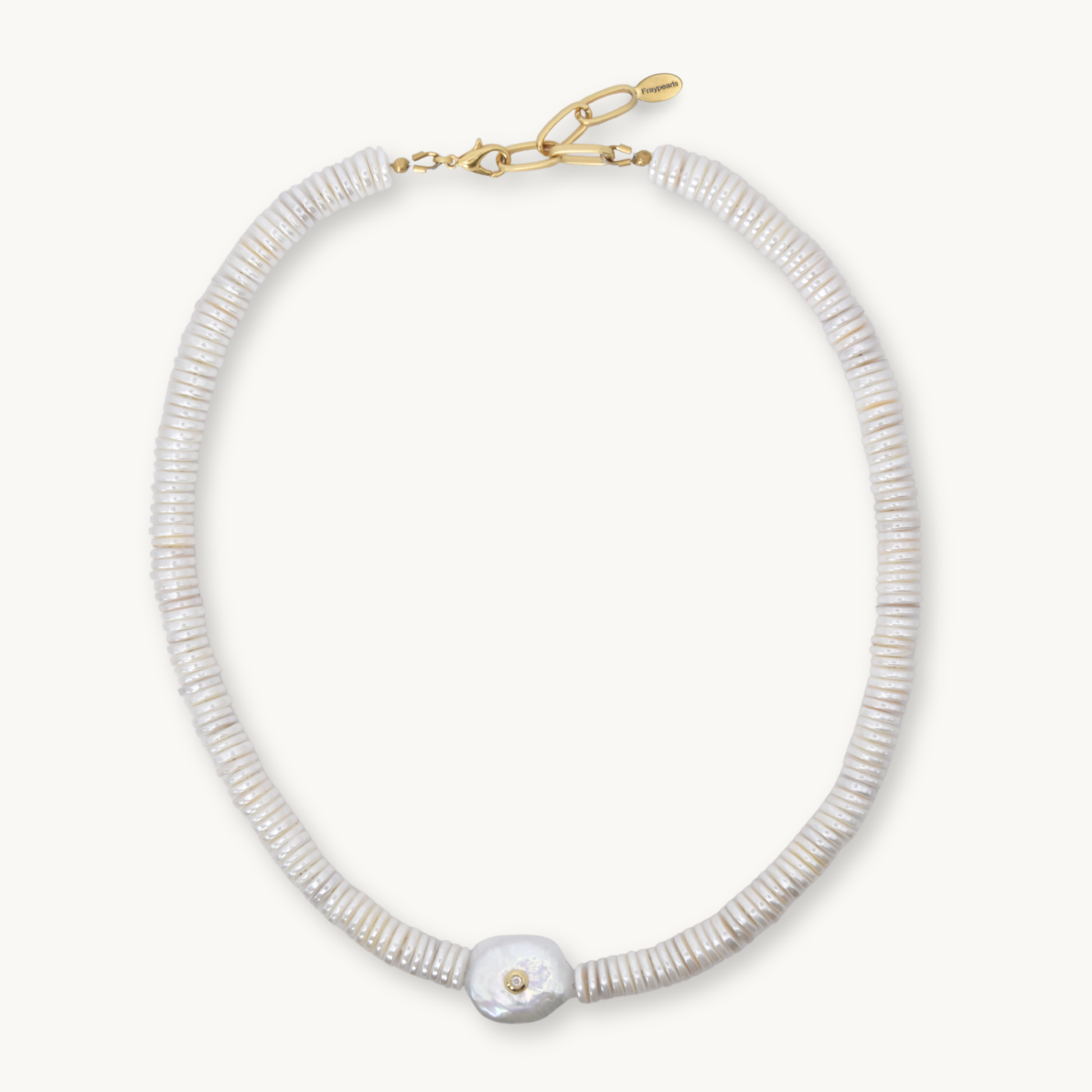 A delicate necklace made of small, tightly packed white beads with a single larger white shell pendant and a gold clasp, shown on a light cream background.