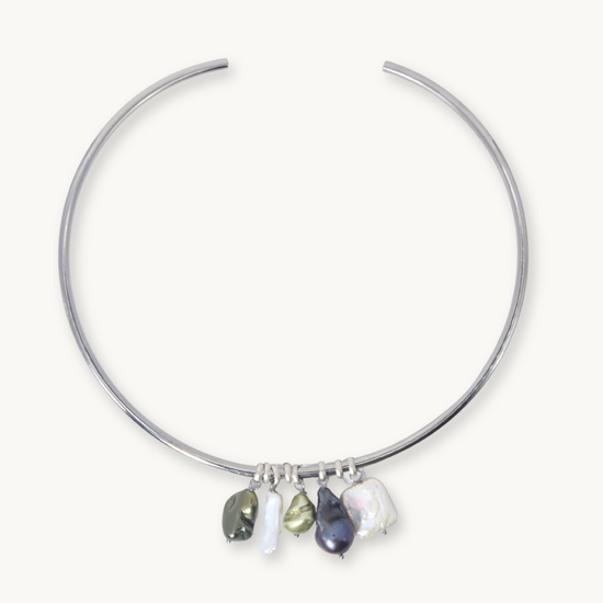 A silver-toned open hoop necklace with five dangling baroque pearl charms in various colors, displayed on a clean off-white background.