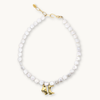 Freshwater coin pearl necklace with a gold bikini top and bottom charm and a gold hook clasp.