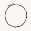 Brown beaded necklace with a pearl pendant on a white background