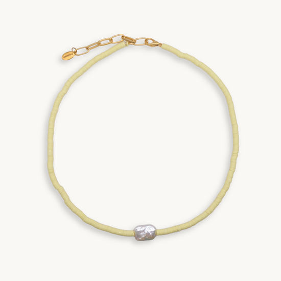 Light yellow beaded necklace with a pearl pendant on a white background