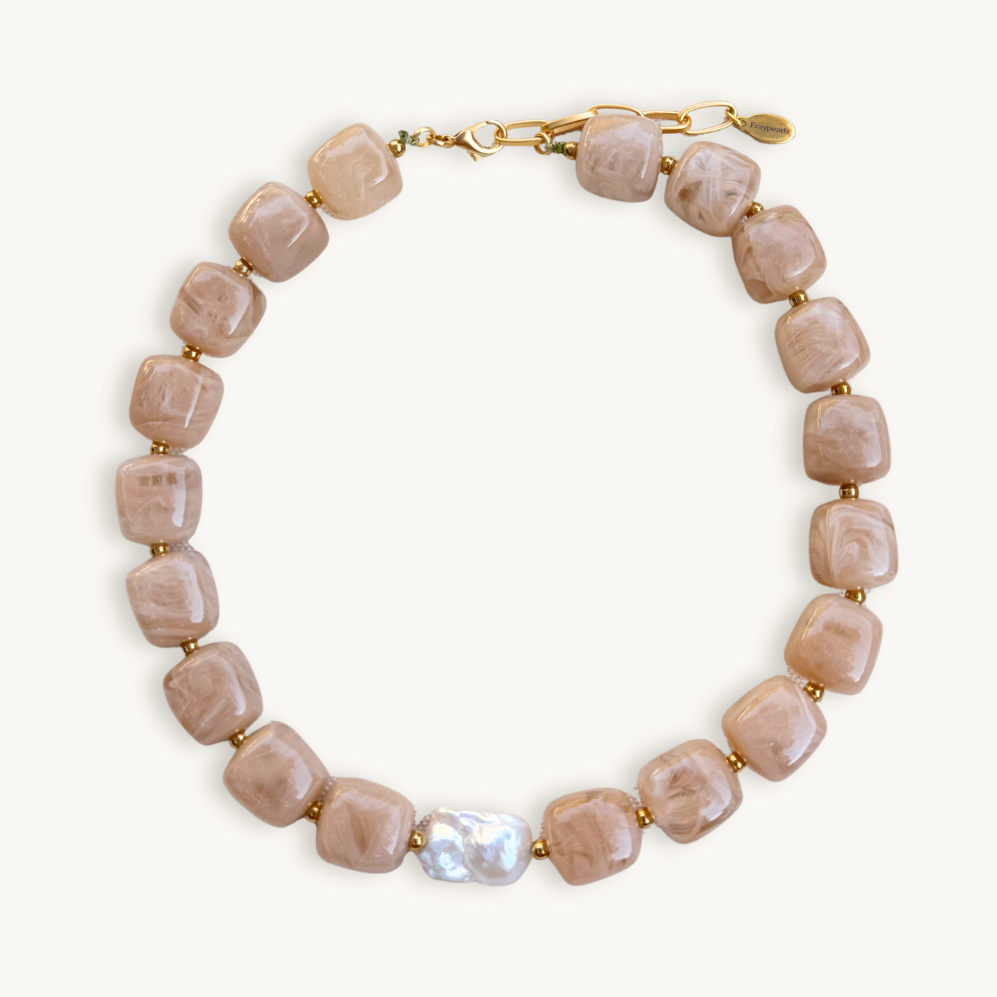 Sand gemstone necklace with square beads, featuring a single irregular white pearl. Gold clasps add elegance against a plain white background.