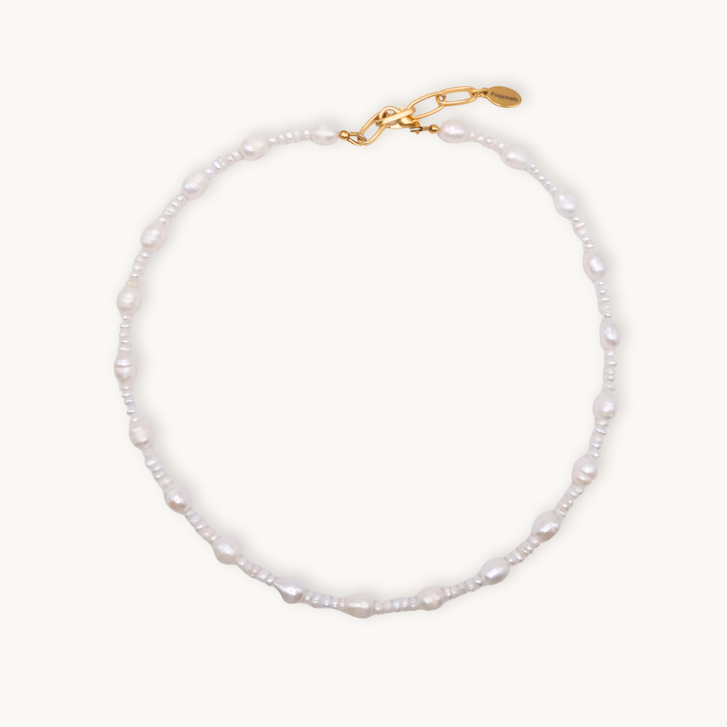 A delicate pearl necklace with a mix of round and irregular pearls, featuring a gold clasp and chain, exudes elegance and timeless beauty.